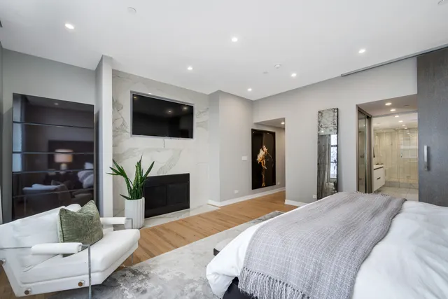 a spacious bedroom with a bed and a flat screen tv