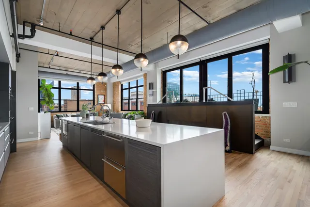 a large kitchen with kitchen island a large counter space a sink and appliances