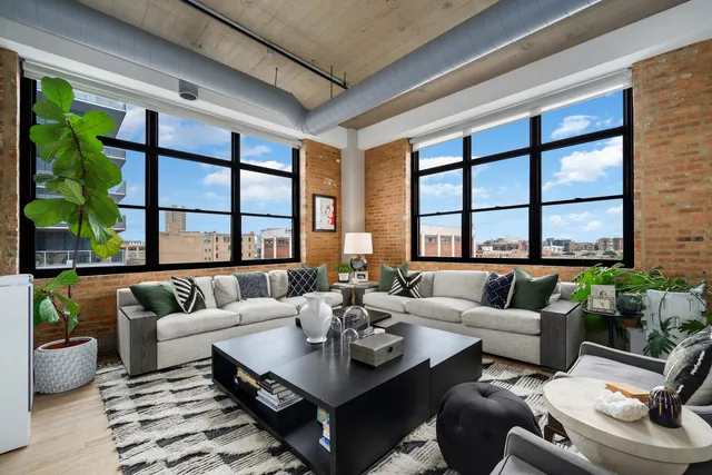 a living room with furniture and floor to ceiling windows