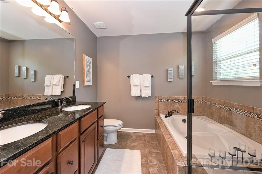 3007 Fallondale Road Waxhaw, NC 28173 - Photo 22 of 46 a spacious bathroom with a granite countertop sink and a mirror