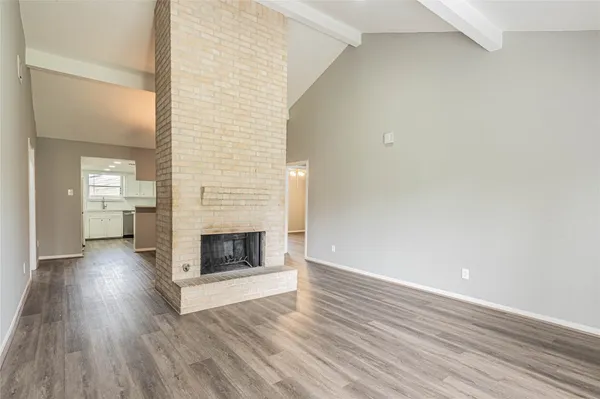 a view of a livingroom with wooden floor and a fireplace