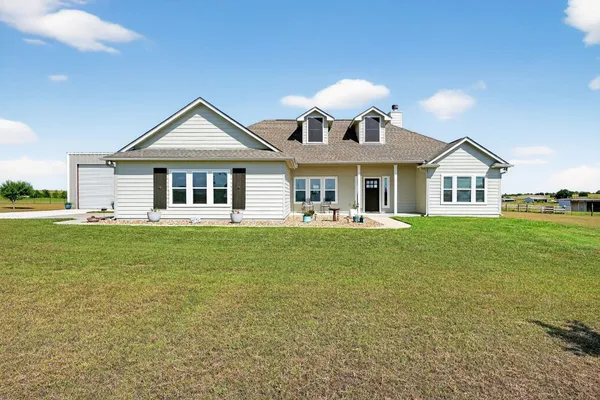 a front view of a house with a garden and yard