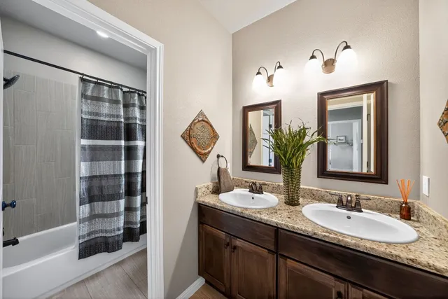 a bathroom with a double vanity sink and a mirror