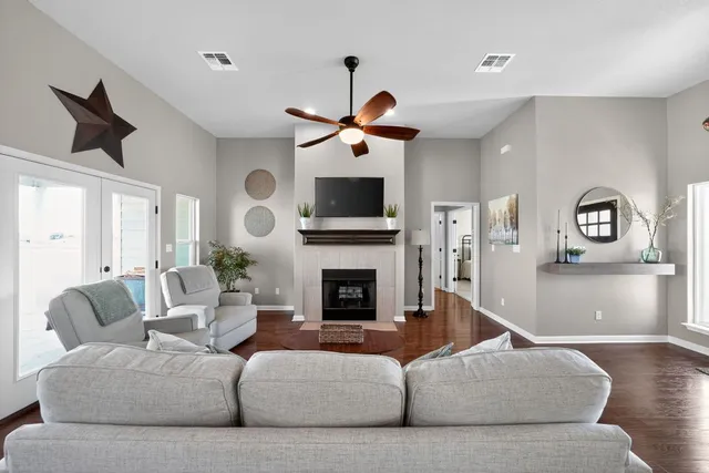a living room with furniture a fireplace and a chandelier