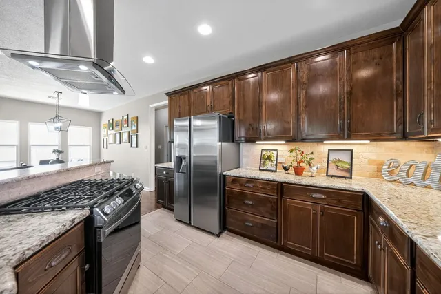a kitchen with stainless steel appliances granite countertop a stove refrigerator sink and cabinets