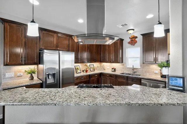a large kitchen with kitchen island a sink stove and refrigerator