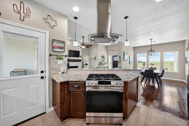a kitchen with stainless steel appliances granite countertop a stove and a wooden floors