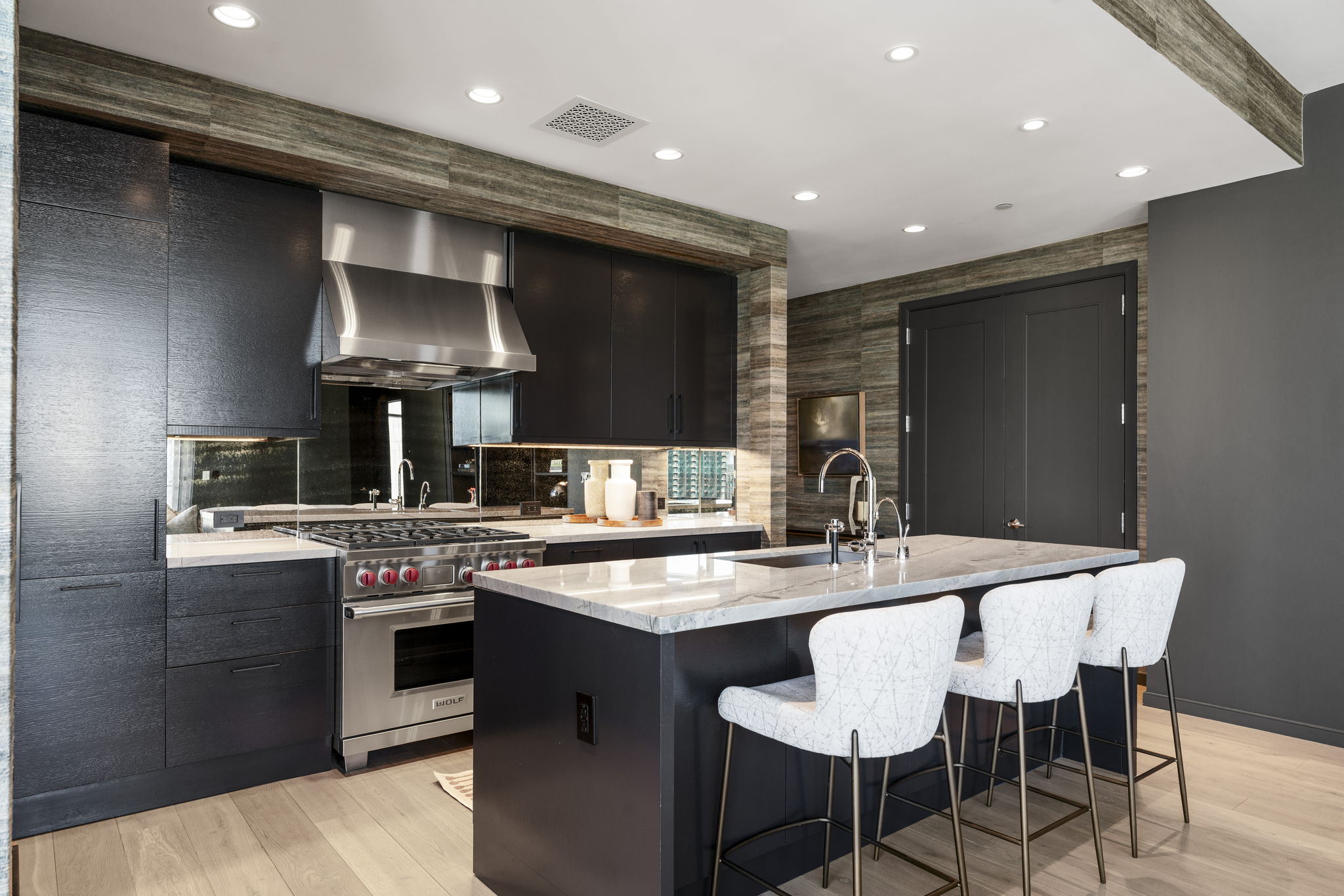 200 Congress Avenue, Unit 21D Austin, TX 78701 - Photo 11 of 34 Kitchen featuring modern cabinets, a kitchen island with sink, and light stone countertops