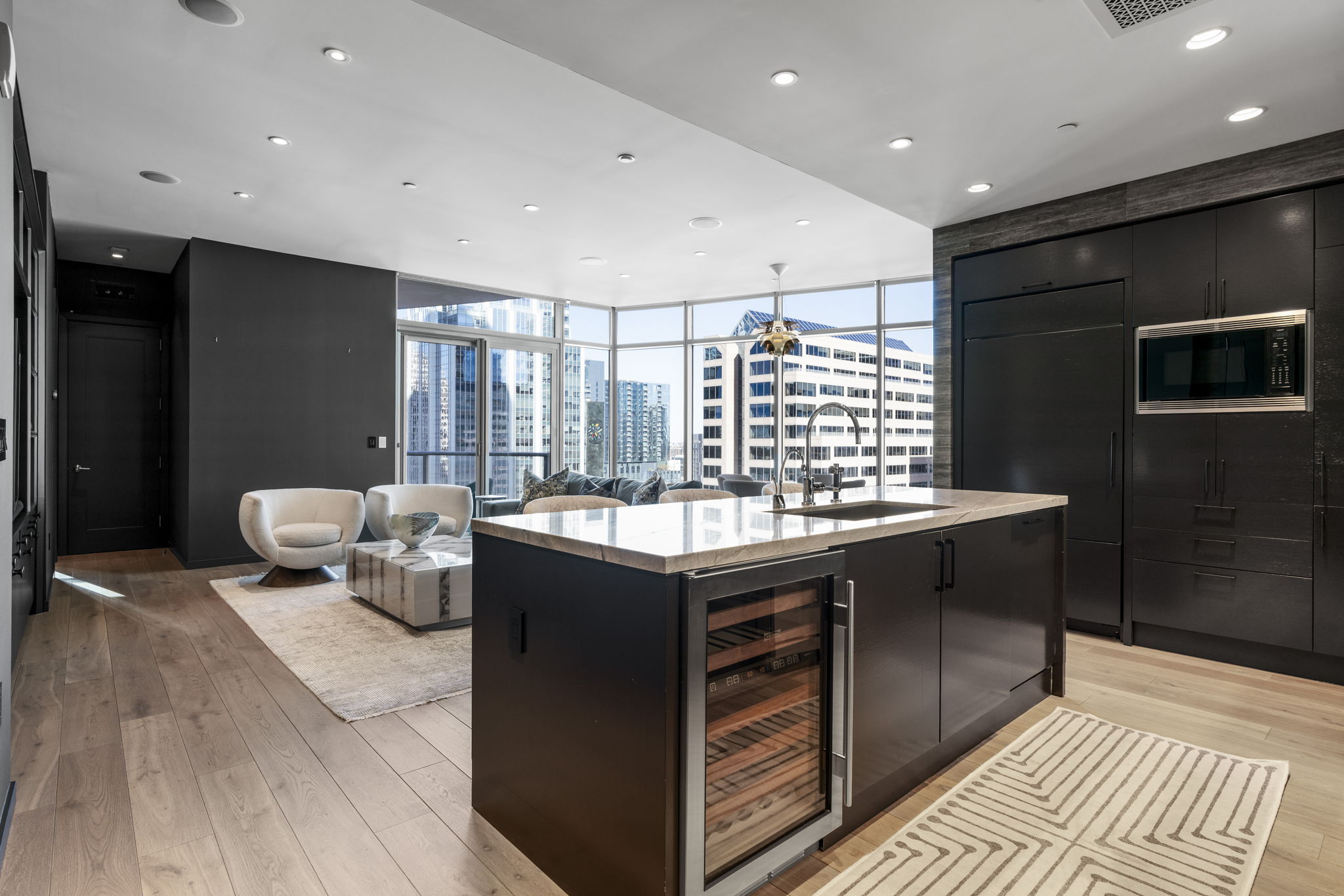 200 Congress Avenue, Unit 21D Austin, TX 78701 - Photo 14 of 34 Kitchen featuring wine cooler, modern cabinets, dark cabinets, built in appliances, and expansive windows