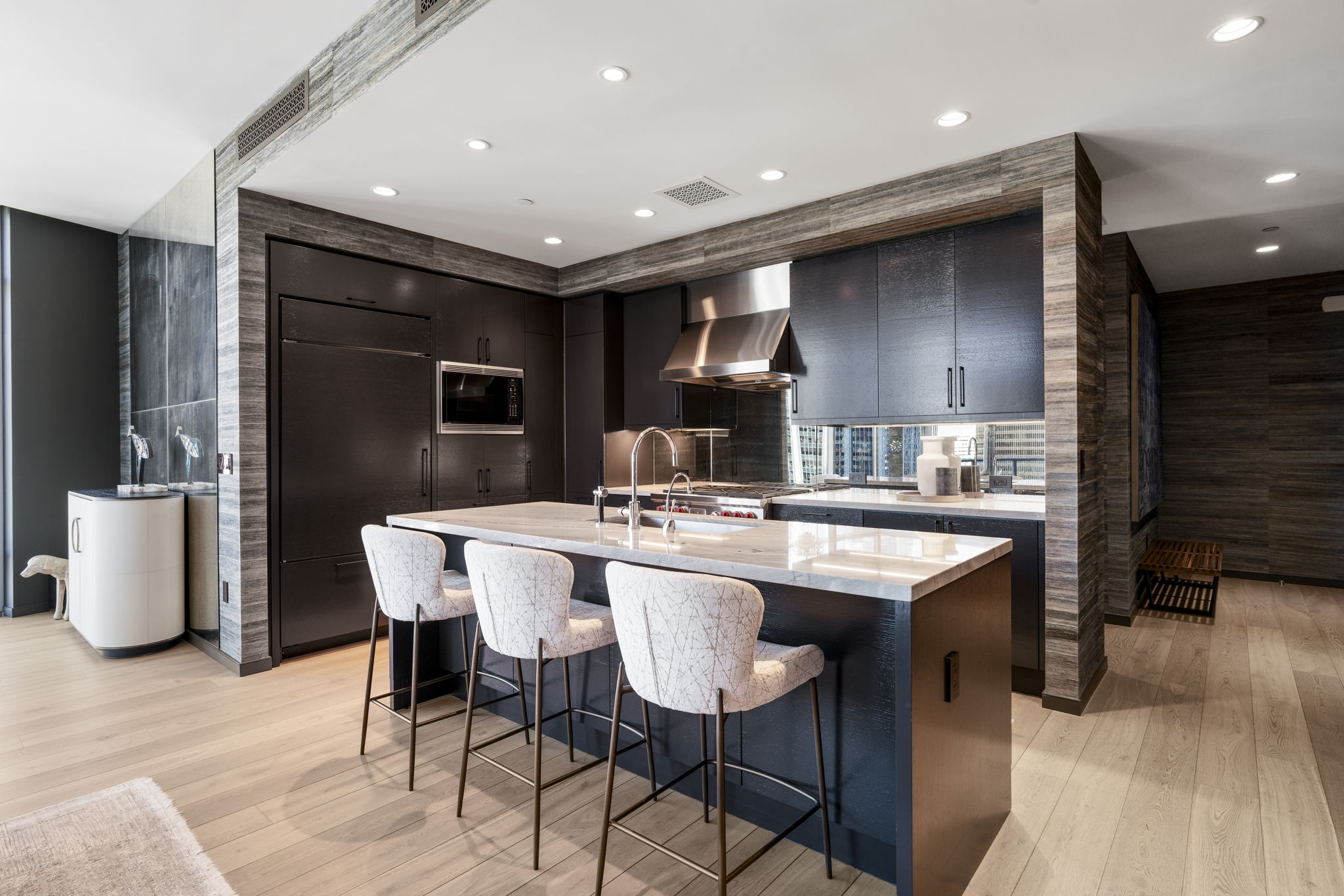 200 Congress Avenue, Unit 21D Austin, TX 78701 - Photo 2 of 34 Kitchen with light stone countertops, a kitchen breakfast bar, dark brown cabinetry, and modern cabinets