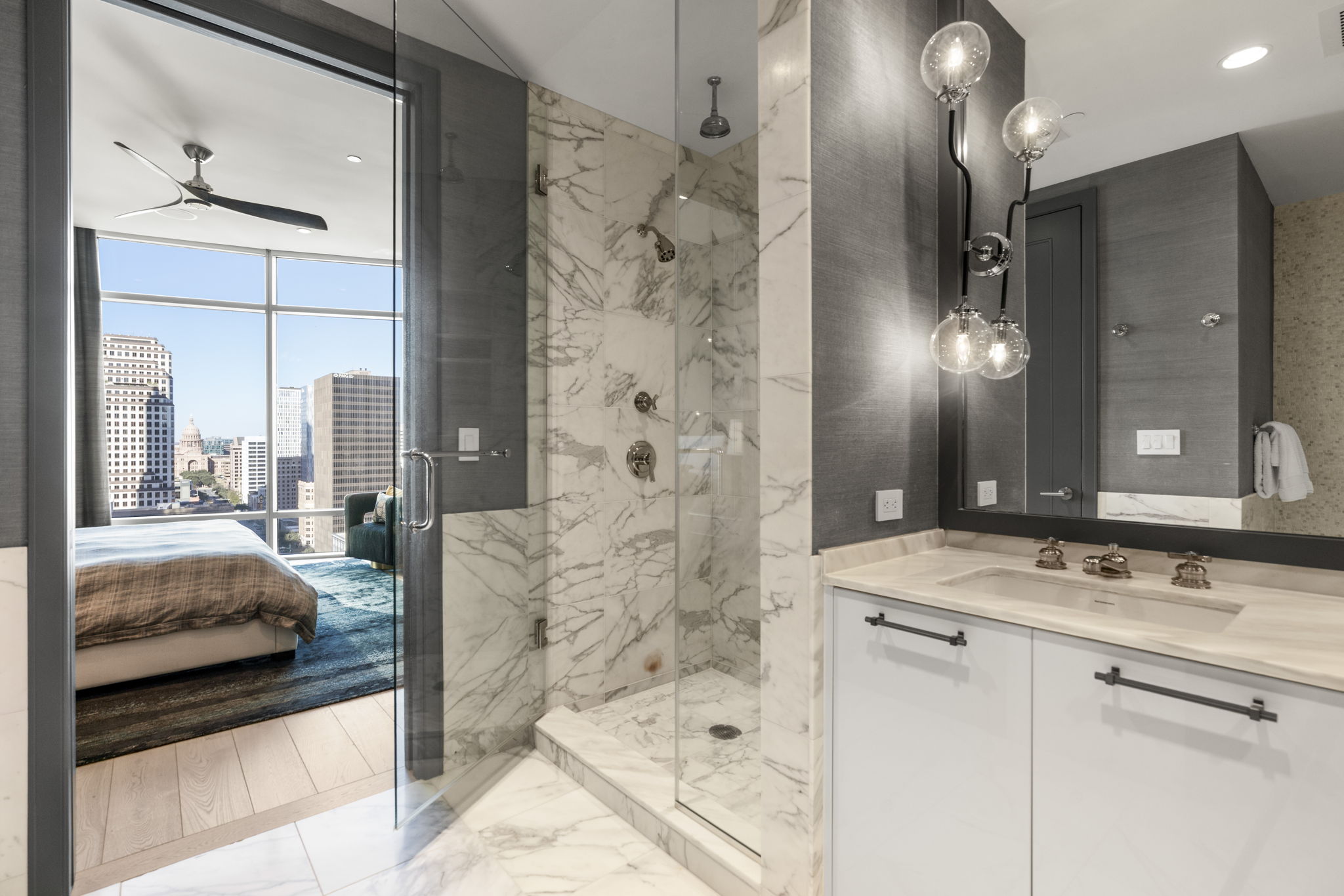 200 Congress Avenue, Unit 21D Austin, TX 78701 - Photo 22 of 34 Ensuite primary bathroom featuring light marble finish flooring and a marble finish shower