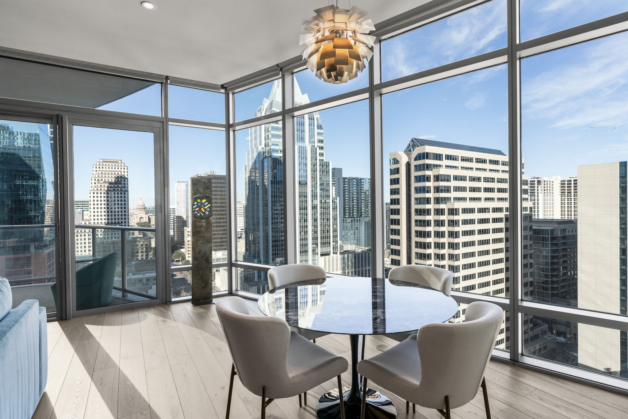 200 Congress Avenue, Unit 21D Austin, TX 78701 - Photo 3 of 34 Dining room with a view of skyline, expansive windows, wood-type flooring, and an abundant amount of natural light