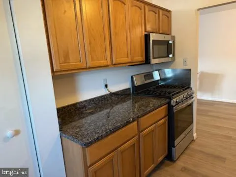 a kitchen with stainless steel appliances granite countertop a sink stove and microwave