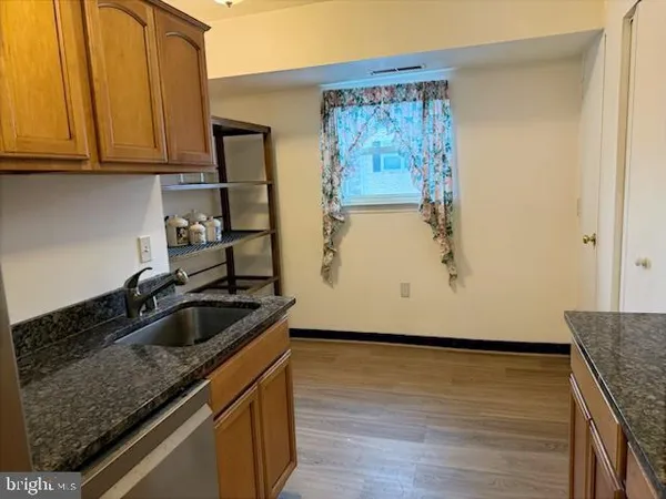 a kitchen with granite countertop a sink stove and cabinets