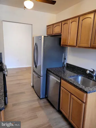 a kitchen with granite countertop a sink a stove and a refrigerator