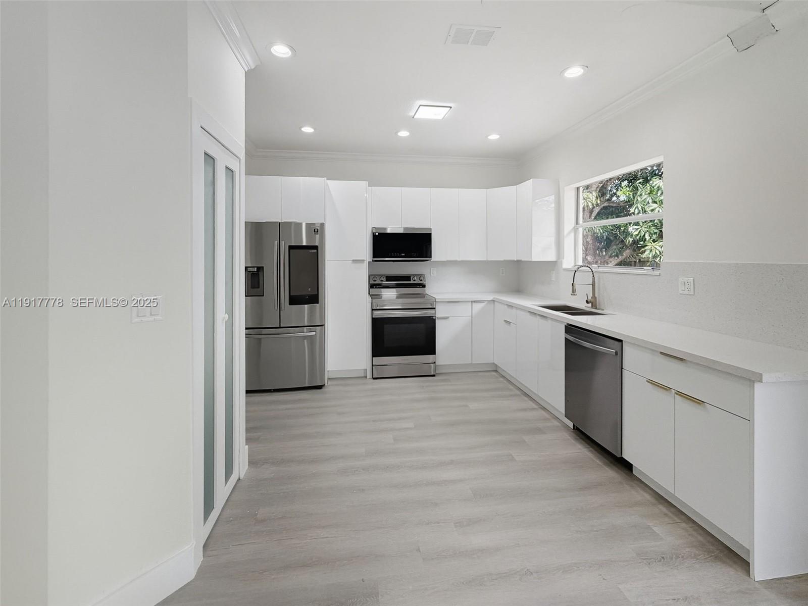 19601 Southwest 128th Court Miami, FL 33177 - Photo 16 of 59 a kitchen with granite countertop a refrigerator and a stove top oven