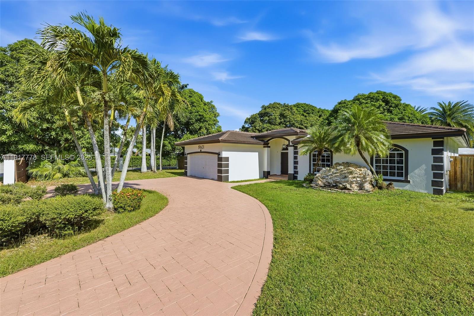 19601 Southwest 128th Court Miami, FL 33177 - Photo 4 of 59 a front view of a house with a yard and trees