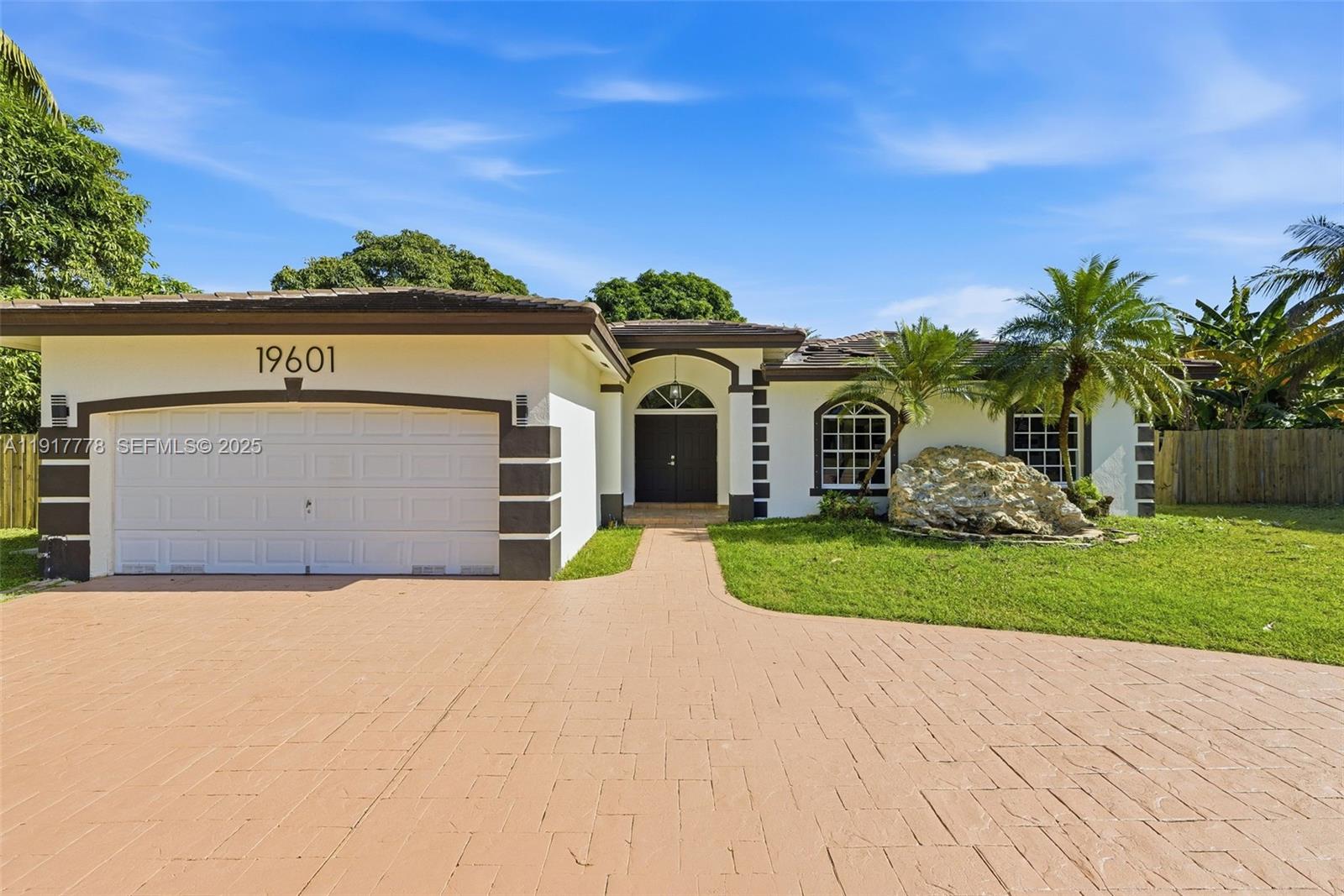 19601 Southwest 128th Court Miami, FL 33177 - Photo 5 of 59 a front view of a house with a yard and garage