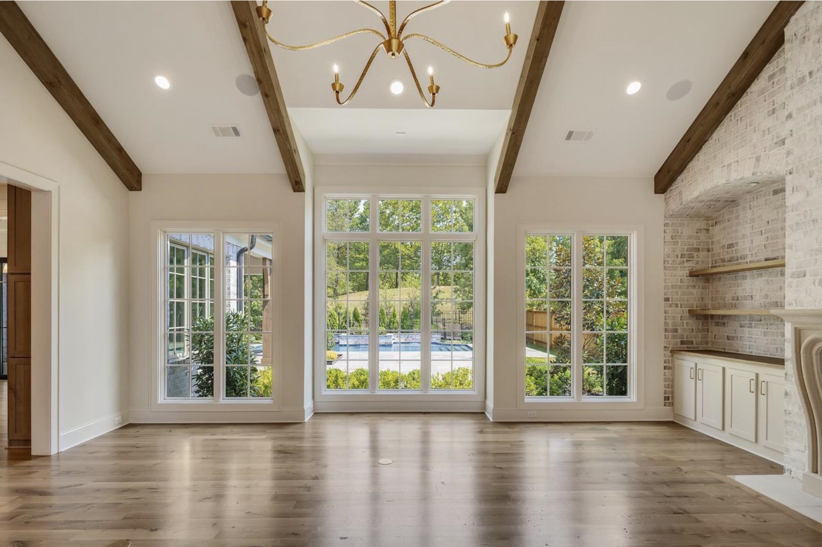 650 Bushchat Lane Collierville, TN 38017 - Photo 13 of 40 Unfurnished living room featuring a chandelier, beam ceiling, light wood-style floors, and recessed lighting