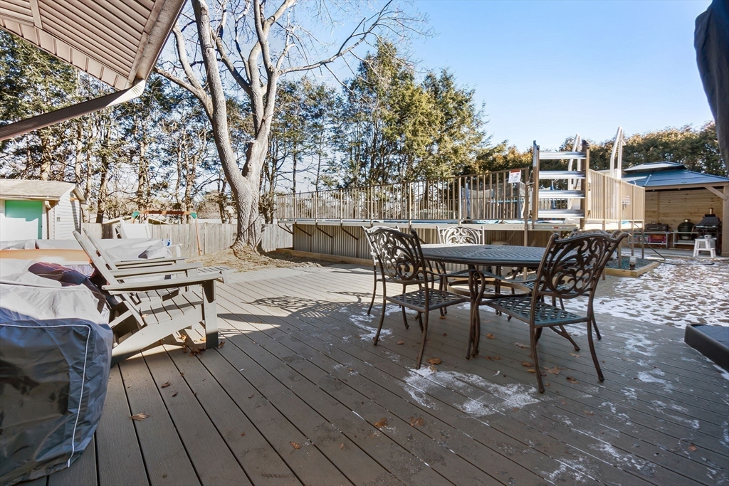 43 Colgate Road Beverly, MA 01915 - Photo 24 of 27 a view of a roof deck with table and chairs a barbeque with wooden floor and fence