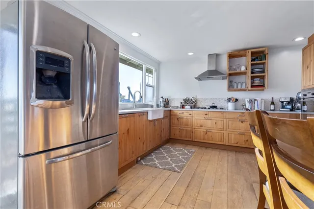 a kitchen with stainless steel appliances granite countertop a refrigerator a sink a stove top oven a counter space and cabinets