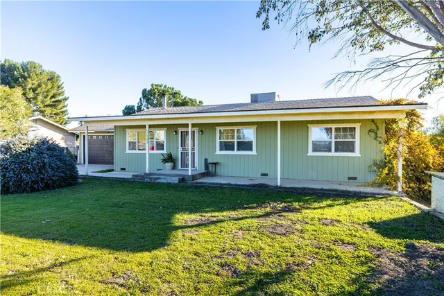 a view of a house with backyard and sitting area