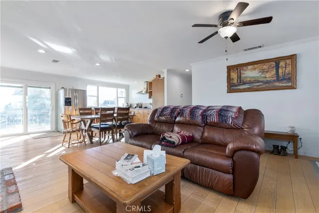 a living room with furniture kitchen view and a large window