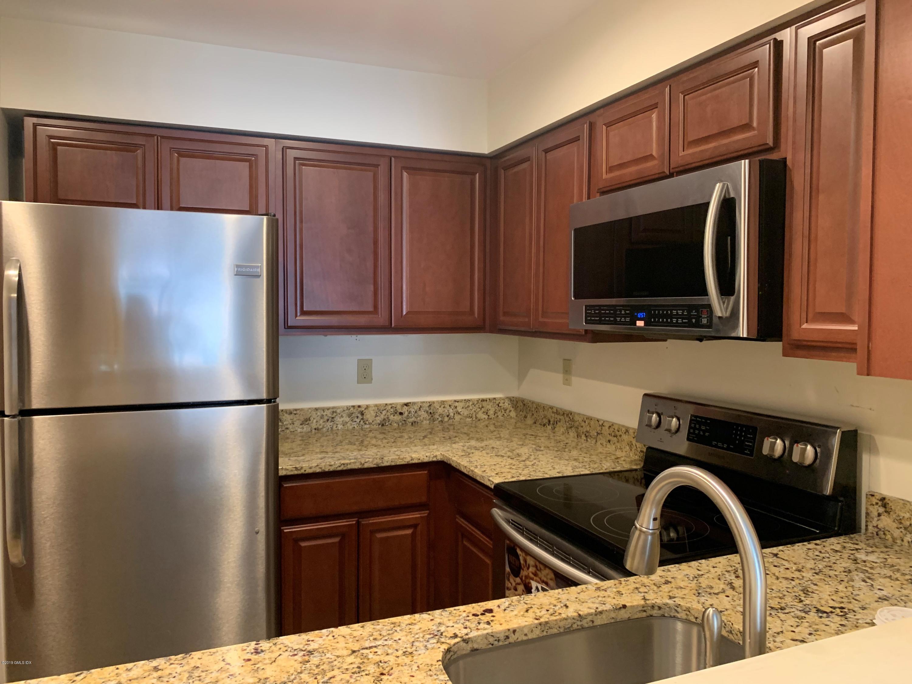 9 River Road, Unit 415 Cos Cob, CT 06807 - Photo 2 of 10 a kitchen with a refrigerator and a sink