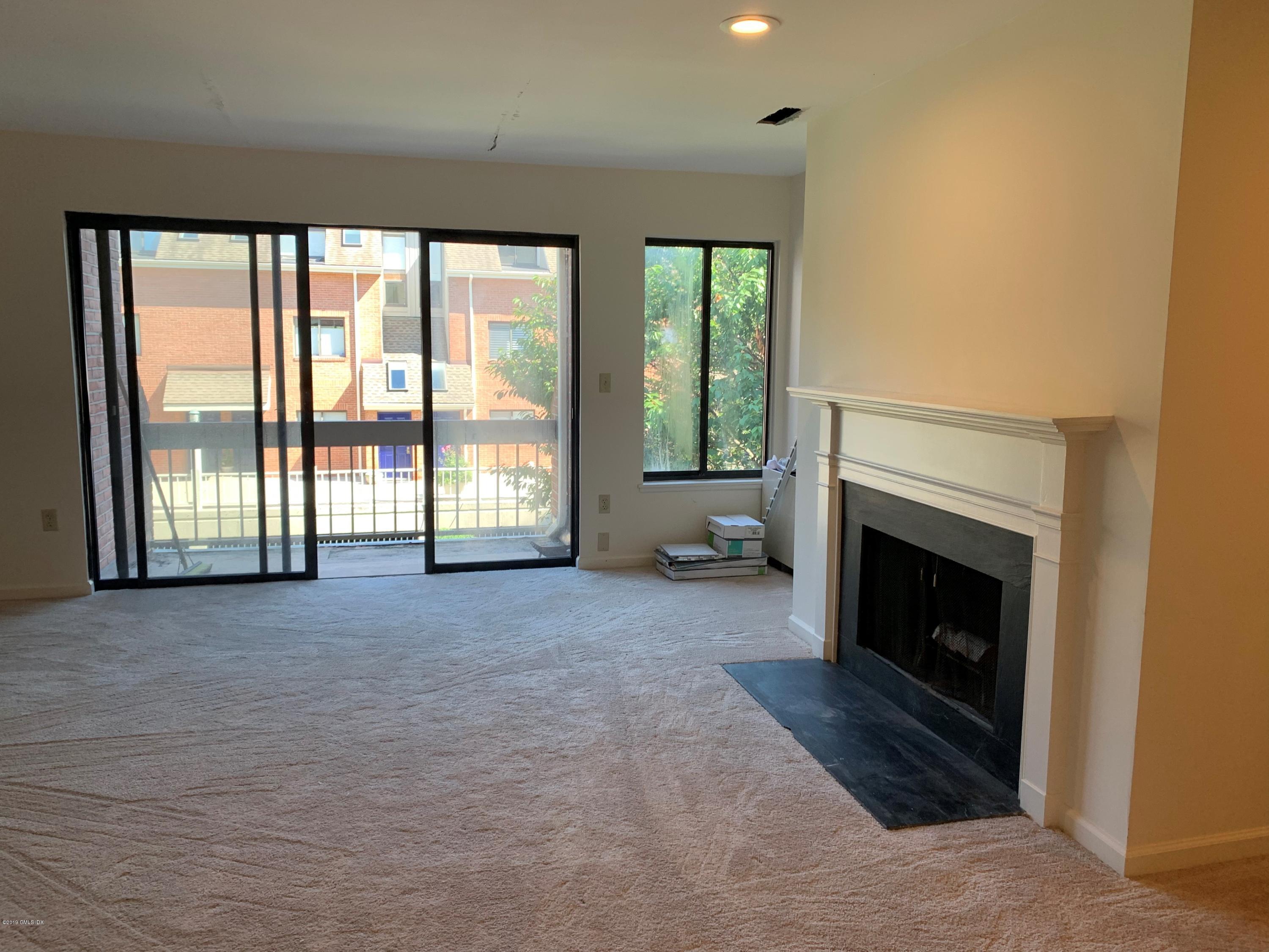 9 River Road, Unit 415 Cos Cob, CT 06807 - Photo 4 of 10 a living room with furniture and a fireplace