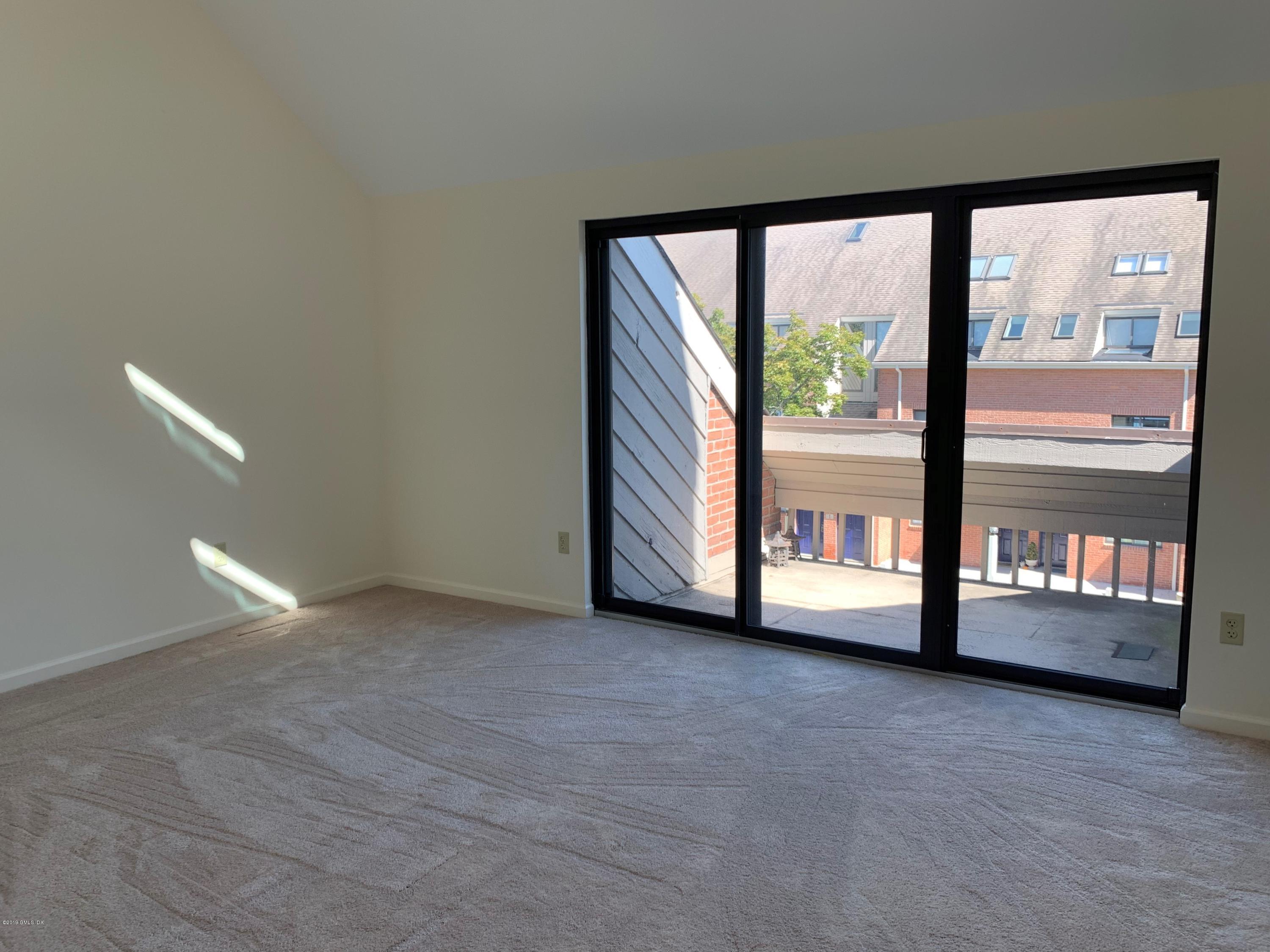 9 River Road, Unit 415 Cos Cob, CT 06807 - Photo 5 of 10 a view of an empty room with large windows