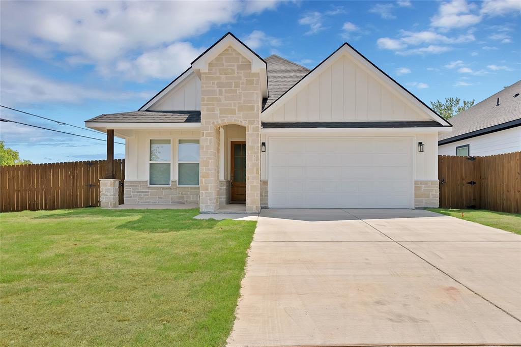 801 Tierney Road Fort Worth, TX 76112 - Photo 1 of 30 Stone and board-and-batten exterior with a two-car garage, covered entry, and wood privacy fencing
