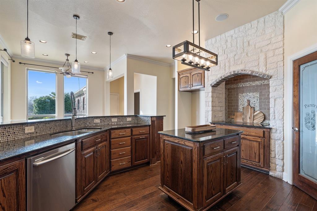 4421 Merritt Road Sachse, TX 75048 - Photo 10 of 38 a kitchen with stainless steel appliances granite countertop a stove a sink dishwasher and a flat tv screen