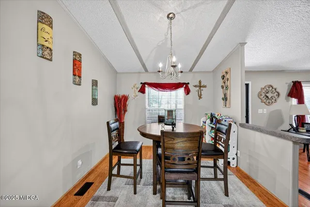 a view of a dining room with furniture and a chandelier