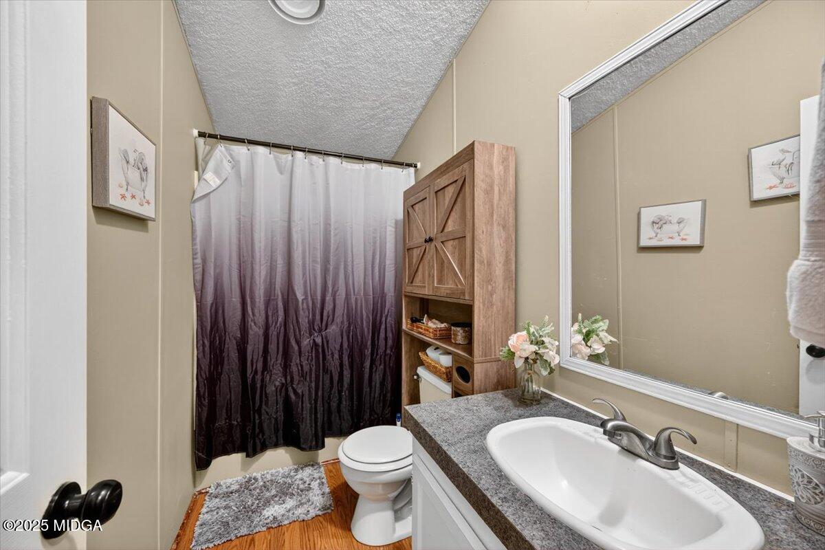 1659 Henderson Road Macon, GA 31217 - Photo 23 of 44 a bathroom with a sink toilet a mirror and vanity