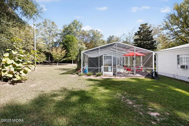 a view of a house with backyard and sitting area