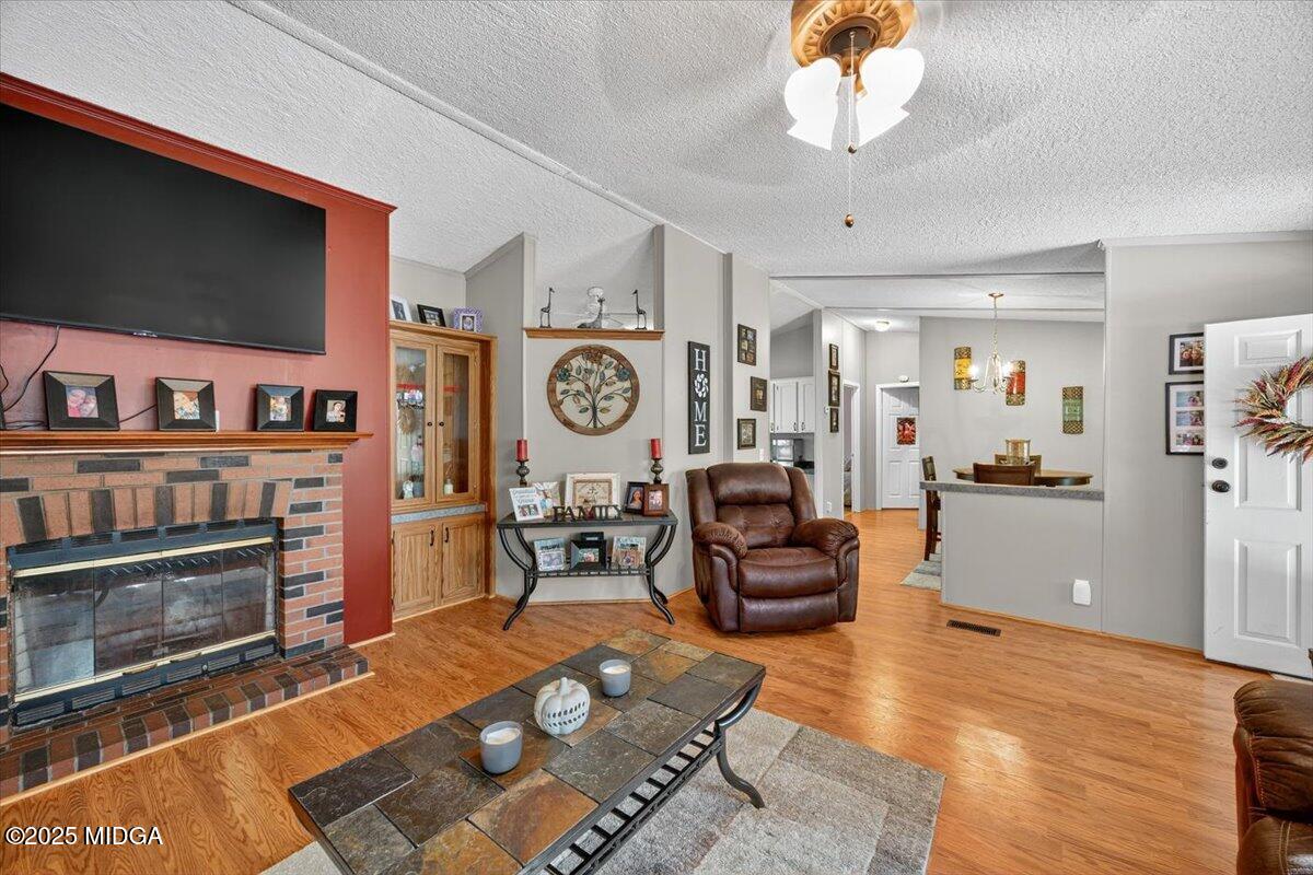 1659 Henderson Road Macon, GA 31217 - Photo 5 of 44 a living room with furniture a flat screen tv and a fireplace