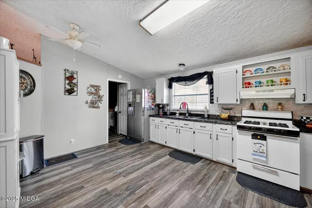 a kitchen with stainless steel appliances granite countertop a stove and a refrigerator