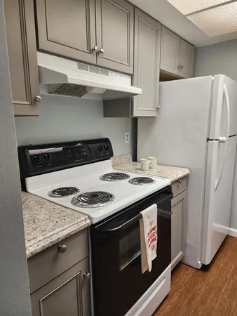 a kitchen with granite countertop a stove and a refrigerator