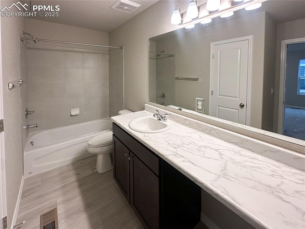 10847 Raylan Way Peyton, CO 80831 - Photo 11 of 40 a bathroom with a granite countertop sink a toilet and shower