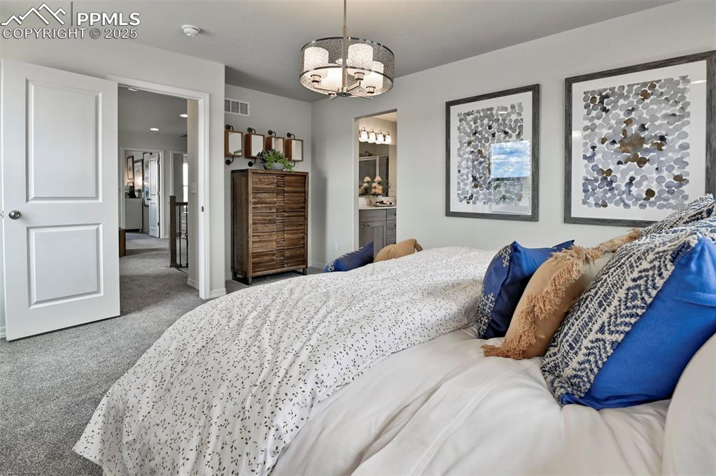 10847 Raylan Way Peyton, CO 80831 - Photo 26 of 40 a bedroom with bed and a chandelier