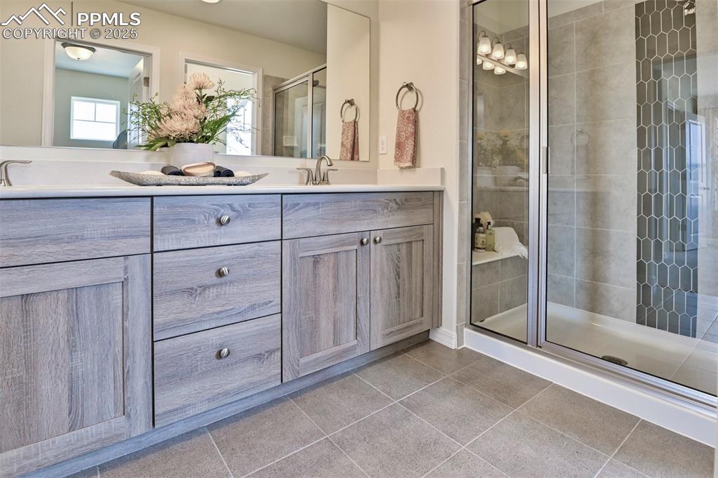 10847 Raylan Way Peyton, CO 80831 - Photo 32 of 40 a spacious bathroom with a double vanity sink and mirror