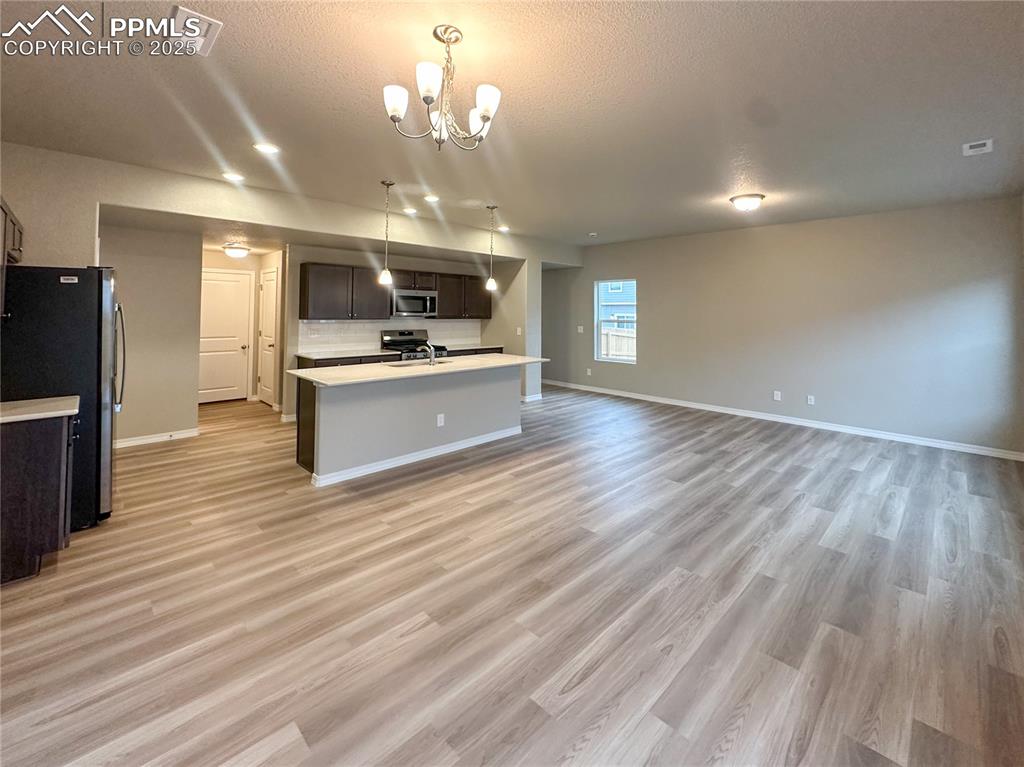 10847 Raylan Way Peyton, CO 80831 - Photo 5 of 40 a view of a kitchen center island wooden floor and living room