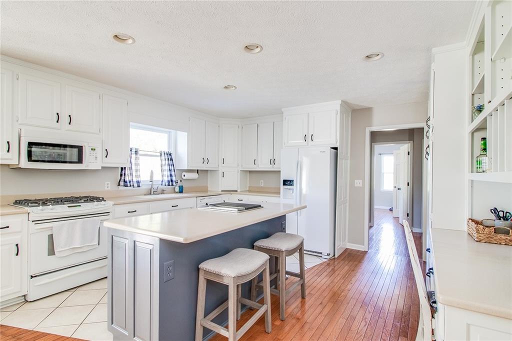 3925 Mark Lake Road Cumming, GA 30028 - Photo 17 of 59 a kitchen with a stove a sink dishwasher a refrigerator with white cabinets and wooden floor