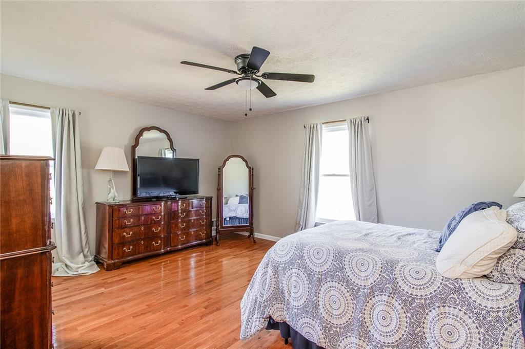 3925 Mark Lake Road Cumming, GA 30028 - Photo 21 of 59 a bedroom with a bed a dresser and flat screen tv