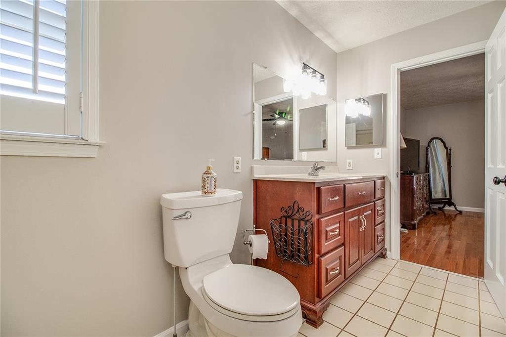 3925 Mark Lake Road Cumming, GA 30028 - Photo 26 of 59 a bathroom with a granite countertop toilet sink and mirror
