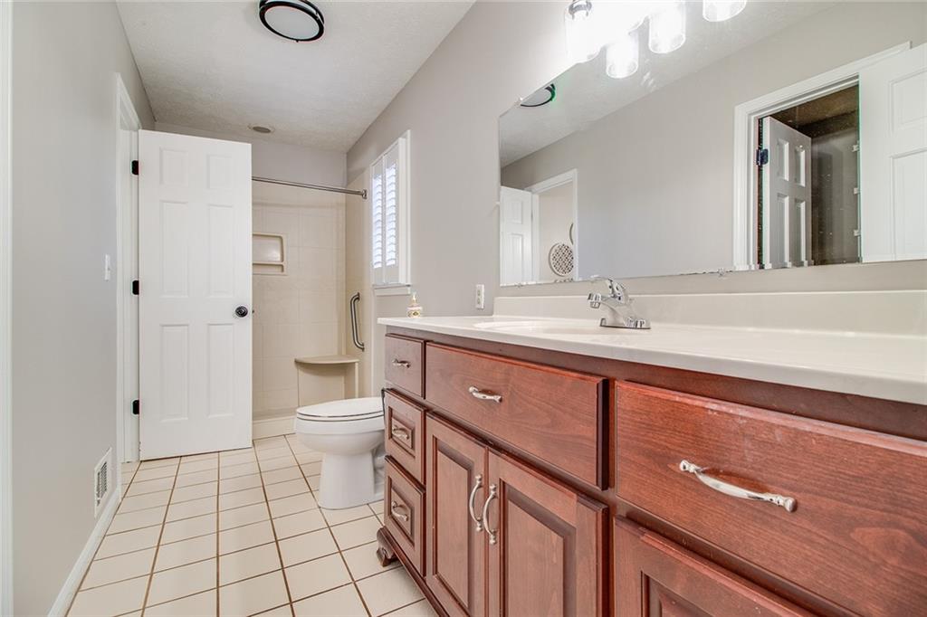 3925 Mark Lake Road Cumming, GA 30028 - Photo 27 of 59 a spacious bathroom with a double vanity sink a toilet and a mirror