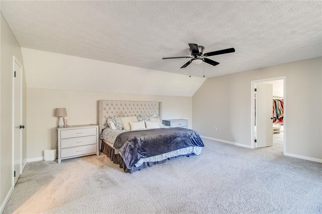 3925 Mark Lake Road Cumming, GA 30028 - Photo 33 of 59 a spacious bedroom with a bed and a ceiling fan
