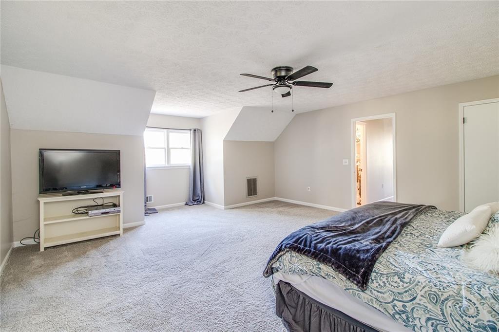 3925 Mark Lake Road Cumming, GA 30028 - Photo 34 of 59 a spacious bedroom with a bed and a flat screen tv