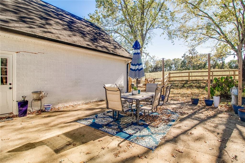 3925 Mark Lake Road Cumming, GA 30028 - Photo 50 of 59 a view of a patio with table and chairs and floor to ceiling window