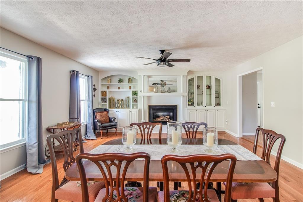 3925 Mark Lake Road Cumming, GA 30028 - Photo 10 of 59 a view of a dining room with furniture a fireplace and wooden floor